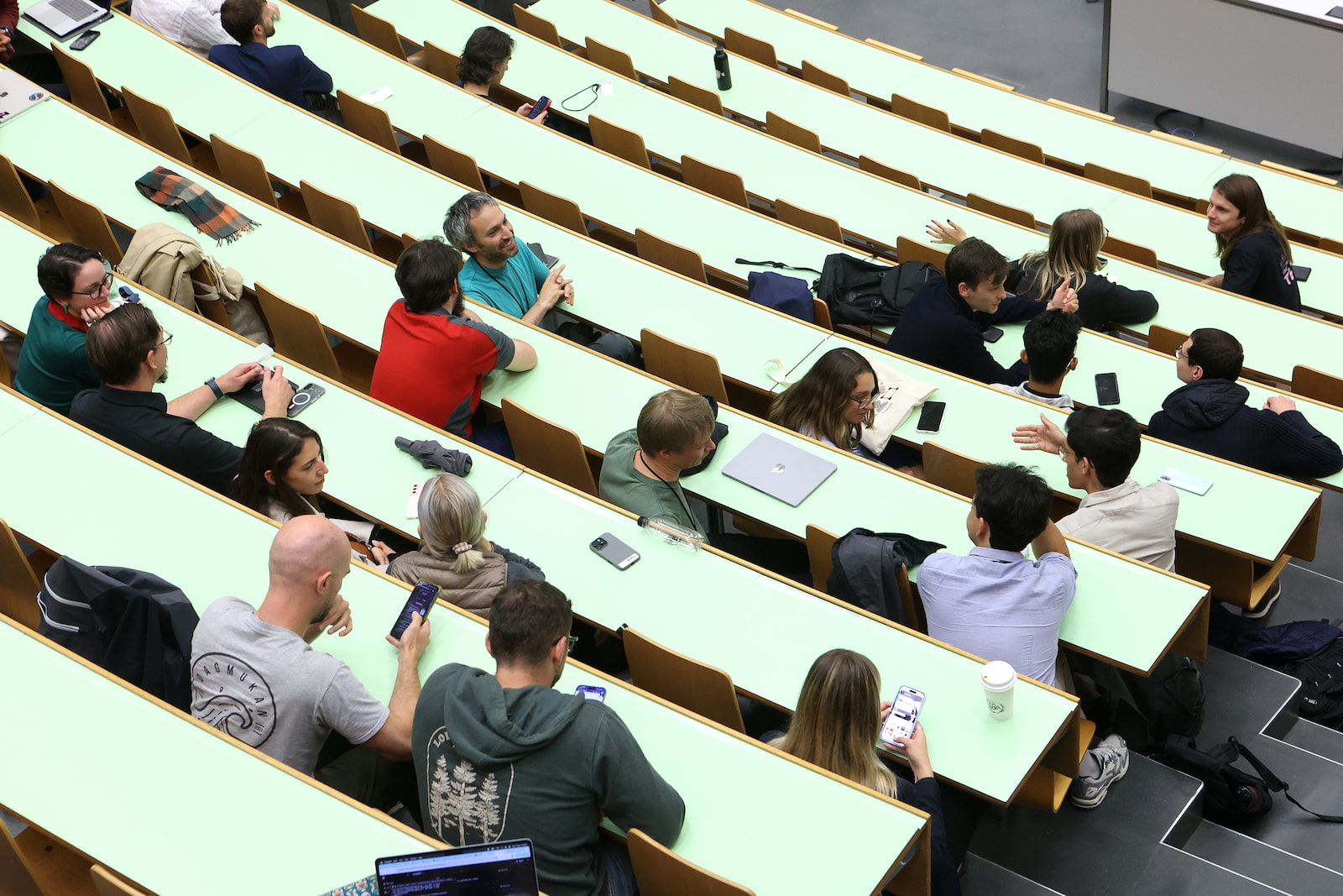 The audience seen from above, spread across the tiered desks